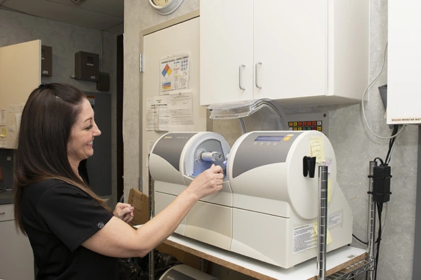 Dental team member using a CEREC restoration milling unit